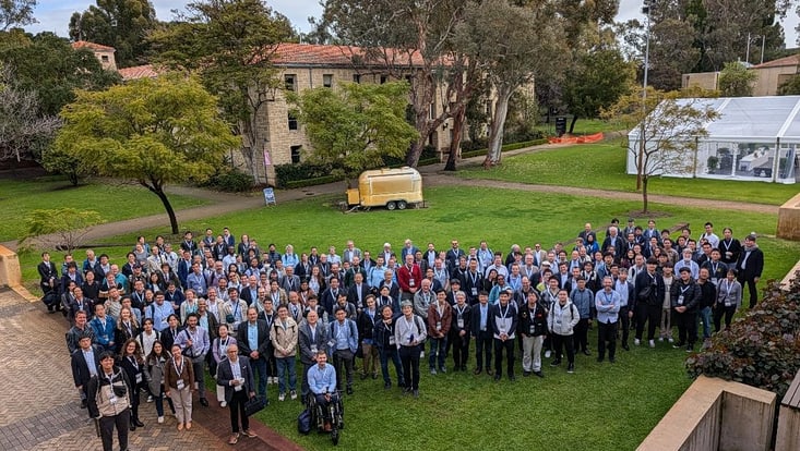 Group of conference participants on Perth University campus in front of conference central meeting area